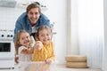 Excited happy young father run push cardboard box with little cute children daughters ride inside, having fun.