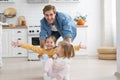 Excited happy young father run push cardboard box with little cute children daughters ride inside, having fun.