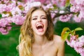 Excited happy young woman with smiling face in spring pink flowers bloom Royalty Free Stock Photo