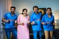 Excited Indian family shouting by celebrating win while watching live cricket match on tv or television at home - Royalty Free Stock Photo