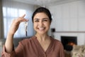 Excited indian female become homeowner look at camera hold key
