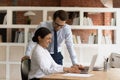 Excited Indian intern and Caucasian mentor having fun in office