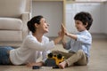 Excited Indian mother with 5s son repairing toy car