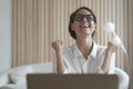 Excited italian lady clenching fists with joy while sitting in front of laptop at workplace Royalty Free Stock Photo