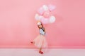 Excited joyful amazing girl with long brunette hair, in princess mask on head jumping in tulle skirt with flying Royalty Free Stock Photo