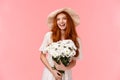 Excited joyful charismatic redhead woman having perfect date, feeling happy and carefree, holding bouquet white flowers