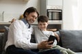 Excited joyful dad and happy teenage son kid sharing smartphone Royalty Free Stock Photo