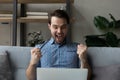 Excited joyful millennial man staring at laptop screen at home Royalty Free Stock Photo