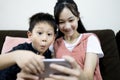 Excited kid boy and child girl are enjoying playing online game on mobile phone,siblings having fun relaxing together,children Royalty Free Stock Photo
