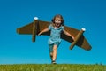 Excited kid with jet pack superhero. Child pilot running against summer sky background. Success, leader and winner