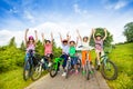 Excited kids in helmets on bikes with hands up Royalty Free Stock Photo