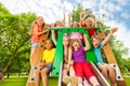 Excited kids on playground chute with arms up Royalty Free Stock Photo