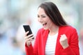 Excited lady celebrating good news checking phone