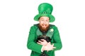 Excited leprechaun in green hat holding pot of gold