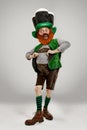 Excited leprechaun in green suit with red beard on white background
