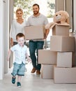 Excited little boy running into his new home. Happy family moving into new purchased property. Father carrying box Royalty Free Stock Photo