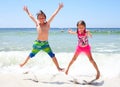 Excited little children jumping together on beach Royalty Free Stock Photo