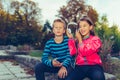 Excited little girl and boy singing and listening music together with headphones and smart phone outdoor Royalty Free Stock Photo