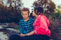 Excited little girl and boy singing and listening music together with headphones and smart phone outdoor Royalty Free Stock Photo