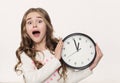 Excited little girl with clock at white background
