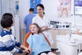 Excited little girl in dentist cabinet for periodic check up