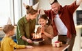 Excited little girl looking at cake and making wish while celebrating Birthday with family at home