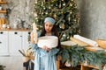 Excited little girl opening christmas present in front of the fir tree Royalty Free Stock Photo