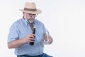 Mature man excitedly holding an empty beer glass and beer bottle: Selective focus. Leisure concept. Royalty Free Stock Photo