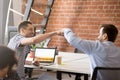 Excited male colleagues give fists bump greeting in office Royalty Free Stock Photo