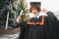 Excited male student in mantle scream graduate from university finish course studying. Happy man triumph holding college Royalty Free Stock Photo