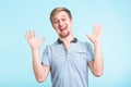 Excited man exclaimed in happiness, gestures actively, expressed great surprisement, over blue background