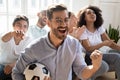 Excited man celebrating goal, watching football with diverse friends Royalty Free Stock Photo