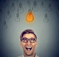 Excited man in glasses with light idea bulb above head has idea Royalty Free Stock Photo