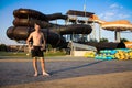 Excited man having fun on water slide in aqua park Royalty Free Stock Photo