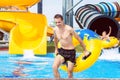 Excited man having fun on water slide in aqua park Royalty Free Stock Photo