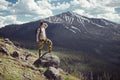 Excited man hiking on a mountain top with backpack enjoy the view and looking for adventures. Royalty Free Stock Photo