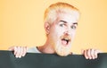 Excited man holding a blank billboard isolated on background. Copyspace. Happy man holding empty white board.