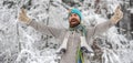 Excited man laughing in snowy park. Winter activities in cold winter weather. Man with skates over shoulder in freezing Royalty Free Stock Photo