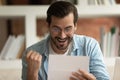Excited man reading postal letter feels overjoyed by great news