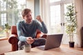 Excited Man Sitting On Armchair At Home With Laptop Making Online Purchase With Credit Or Debit Card Royalty Free Stock Photo