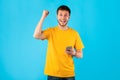 Excited man using mobile phone, celebrating online win Royalty Free Stock Photo