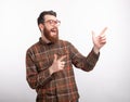 Excited man is pointing at his left side looking there on white background. Royalty Free Stock Photo