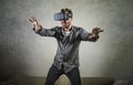 Excited man wearing virtual reality VR goggles headset experimenting 3d illusion playing video game touching illusion surprised at Royalty Free Stock Photo