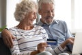 Excited mature couple making payment by credit card online