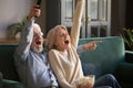 Excited mature couple, man and woman watching football, celebrating victory Royalty Free Stock Photo