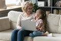 Excited mature grandmother and granddaughter using laptop, having fun Royalty Free Stock Photo