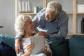 Smiling mature couple have fun using tablet at home Royalty Free Stock Photo