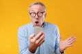 Excited mature man using mobile phone, celebrating online win Royalty Free Stock Photo