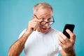 Excited mature man using mobile phone, looking at screen Royalty Free Stock Photo