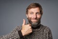 Excited mature man in warm sweater giving thumb up Royalty Free Stock Photo